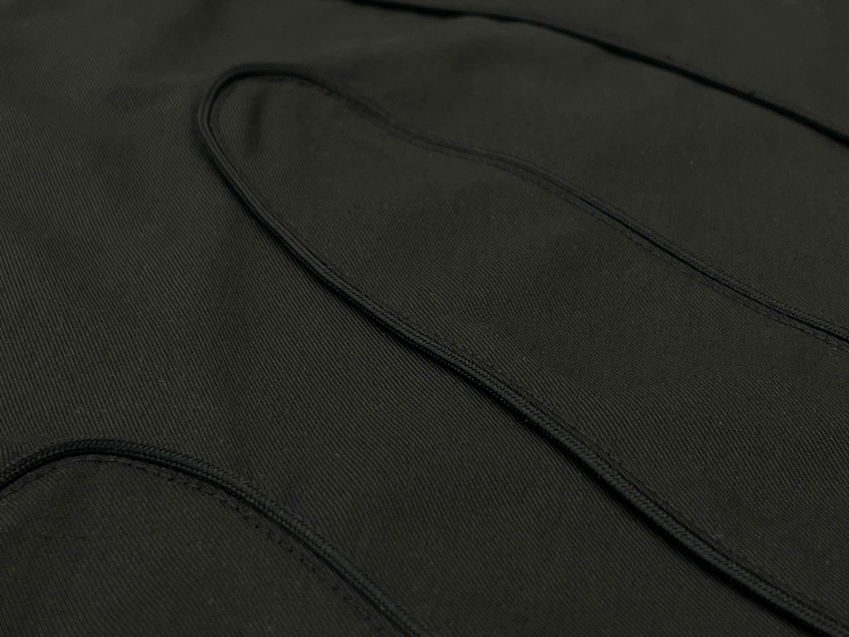The curved, raised seams on the garment produce a subtle 3D effect, enhancing its contemporary style.