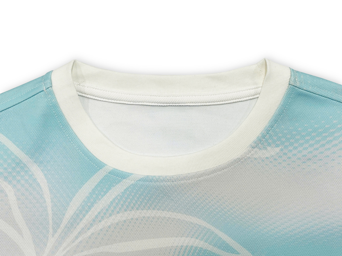 Pastel blue tee with soft floral-wave print.