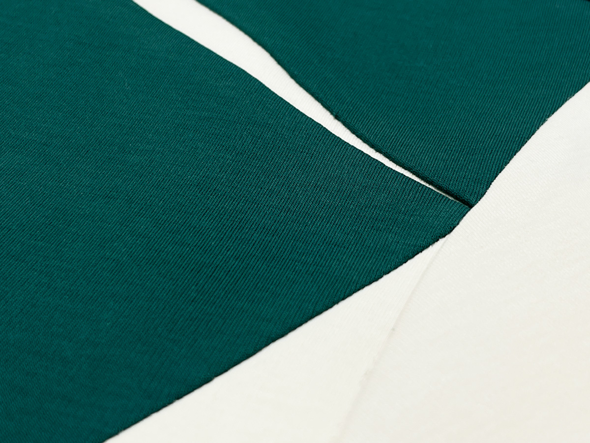 The moss green and cream tones are seamlessly pieced together with panel-cut precision for a premium, cohesive look.